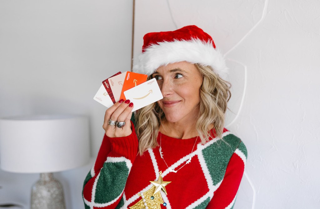 woman in santa hat holding amazon gift cards