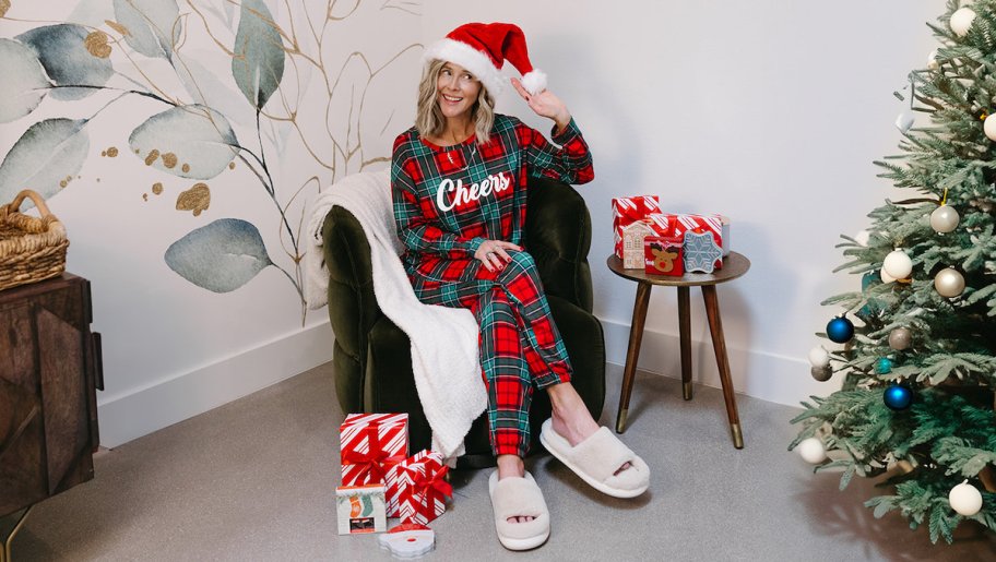 woman sitting in chair with holiday pajamas and gifts
