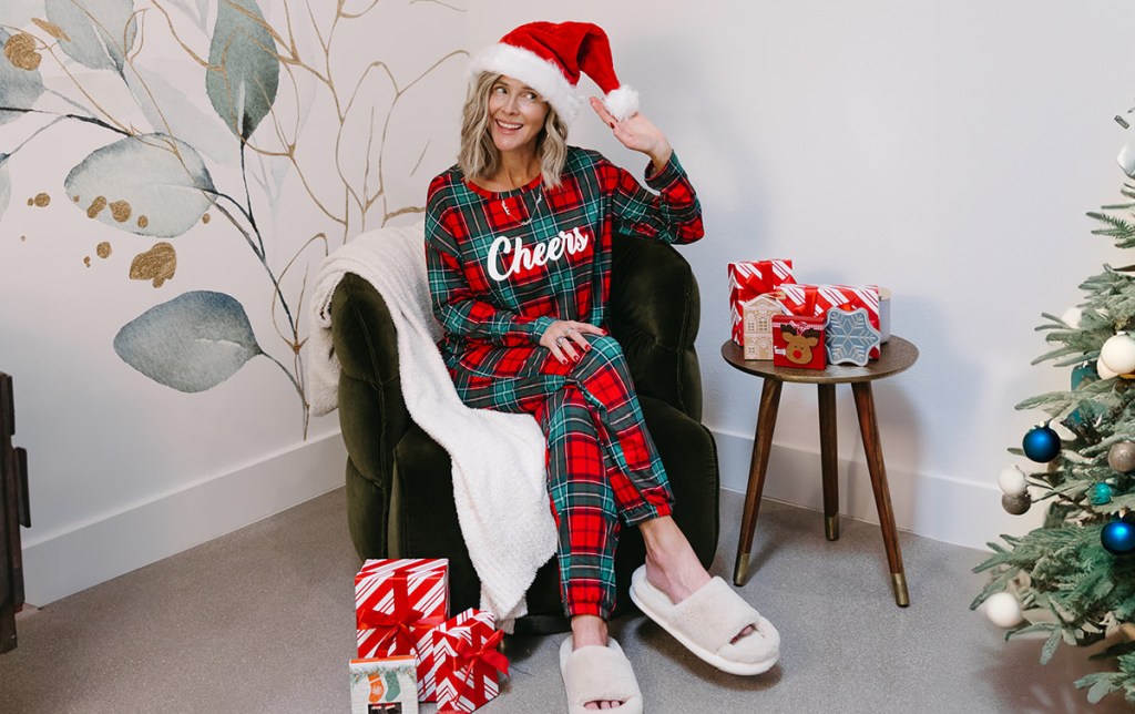 woman wearing christmas pajamas and santa hat with presents