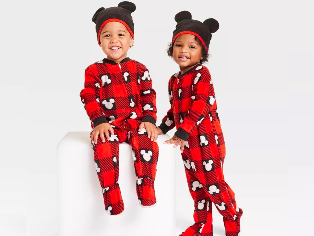 two kids wearing matching red and black disney pajamas