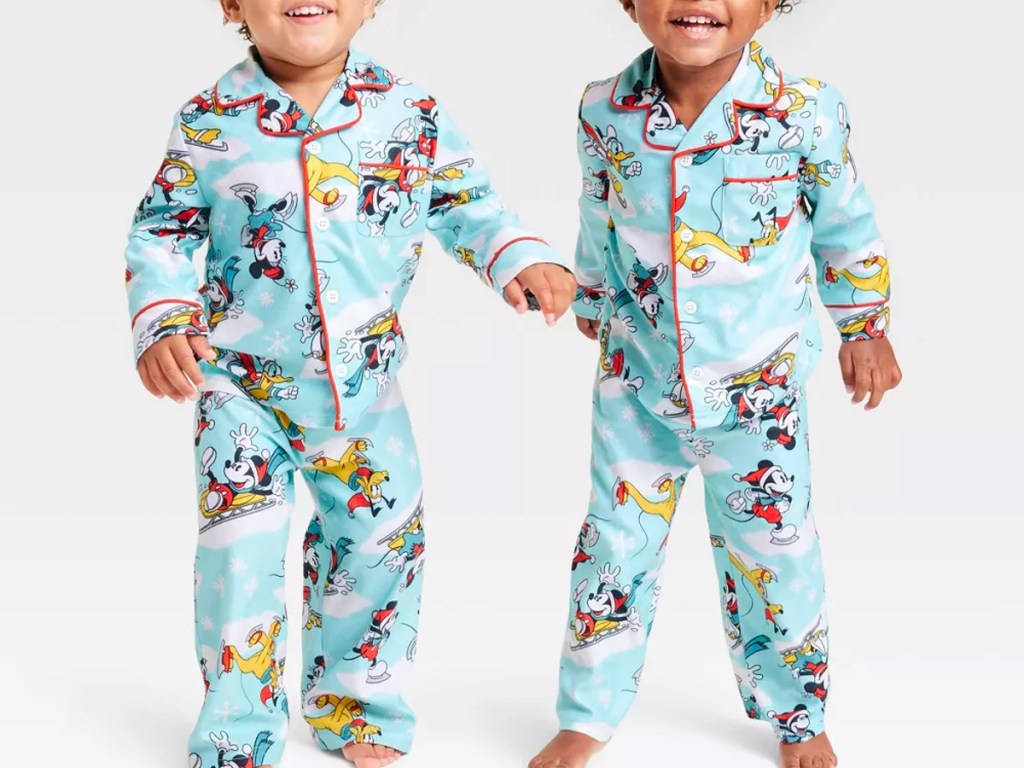 two toddlers wearing blue disney pajamas