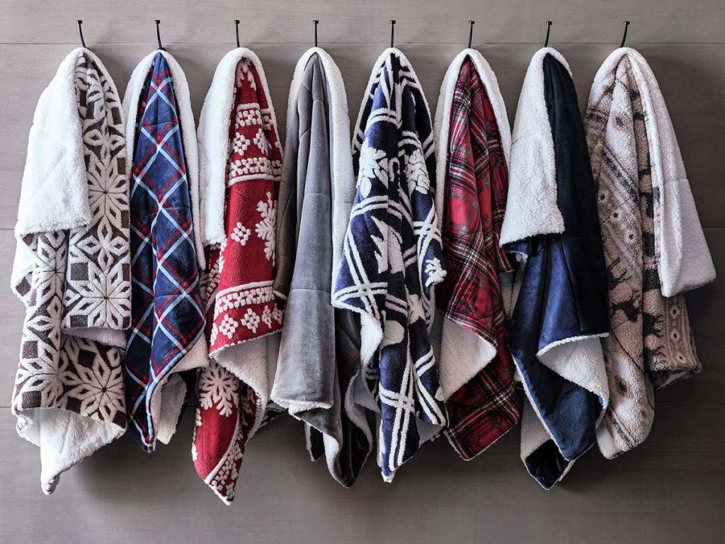 display of hung up sherpa throw blankets with multiple designs on them