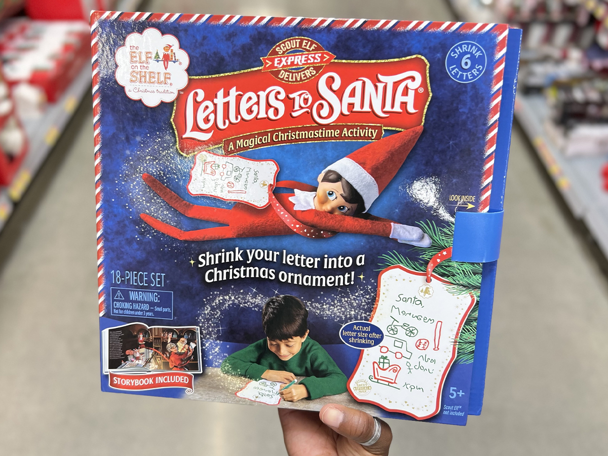 hand holding elf on the shelf letters to santa book