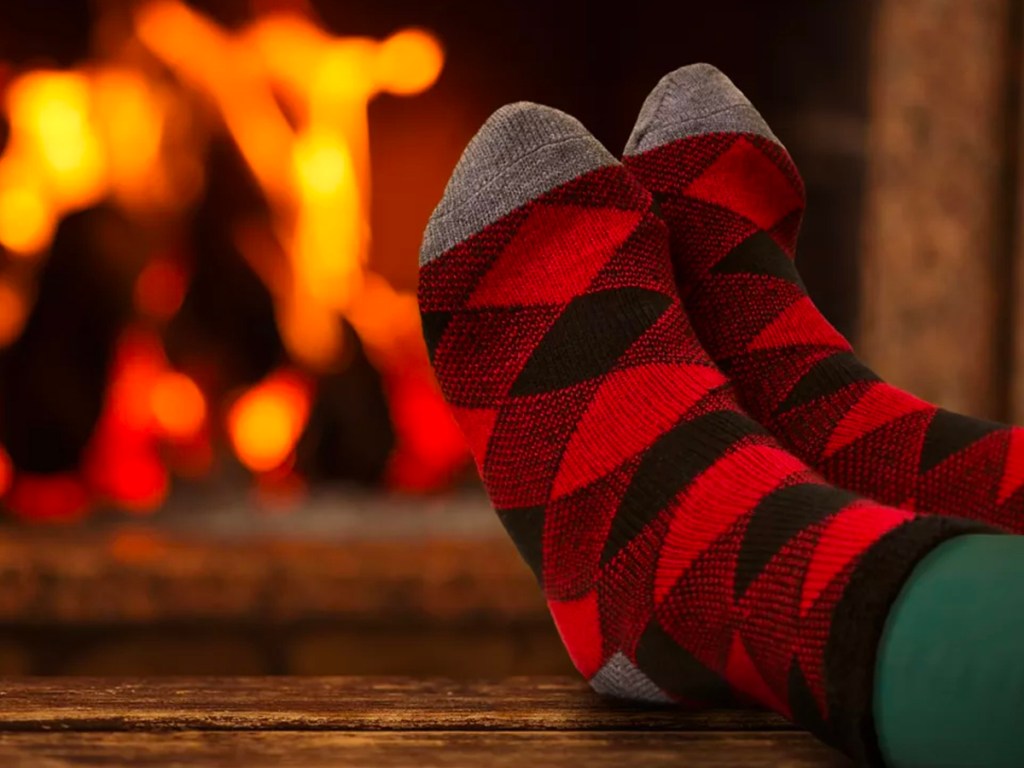 someone wearing red black plaid socks next to fire