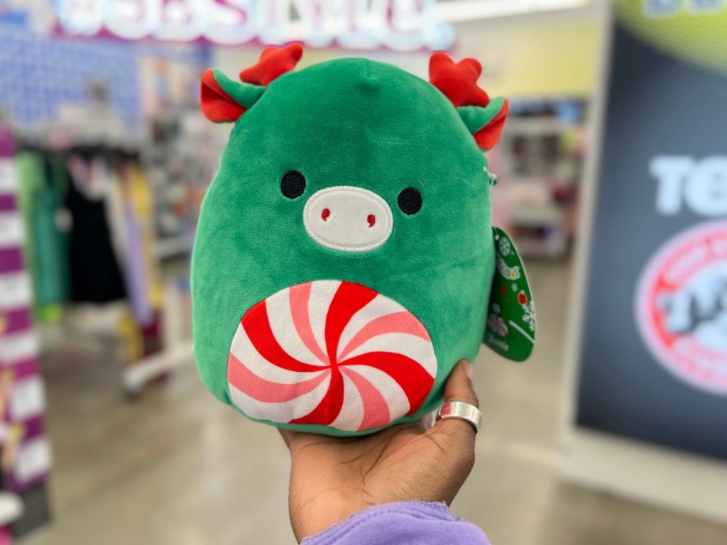 hand holding up a green squishmallows peppermint moose in a five below store