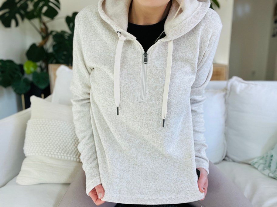 Woman wearing cream zip-up sweatshirt