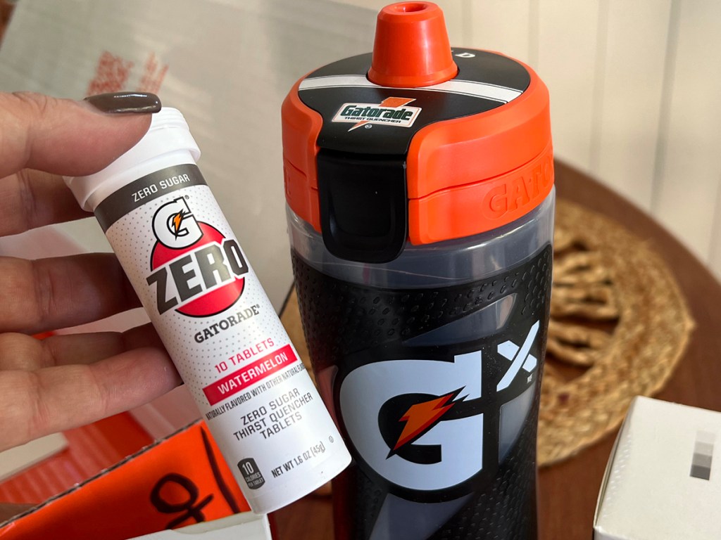 hand holding gatorade tablets next to bottle
