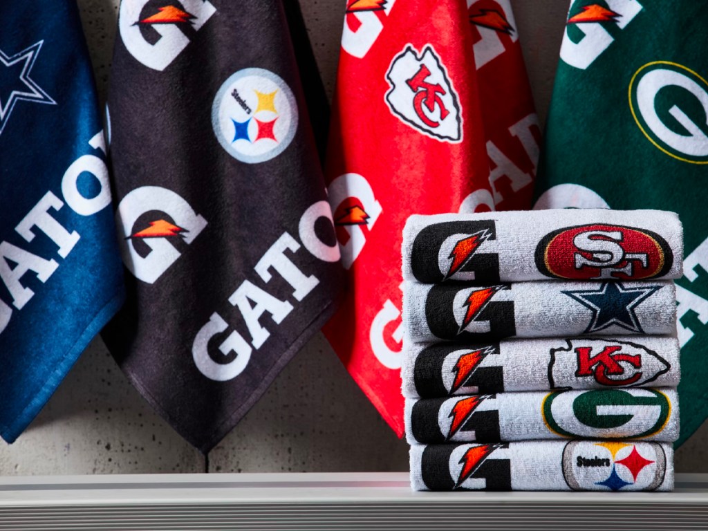 gatorade towels folded on bench with towels hanging in background