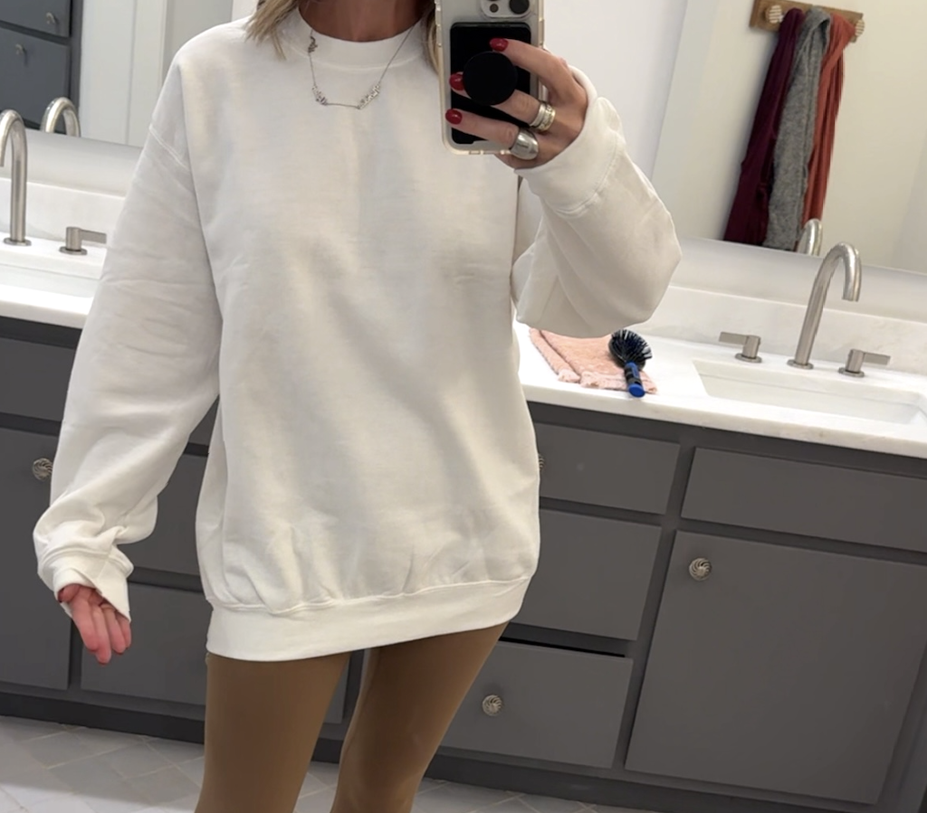 woman wearing white sweatshirt and tan leggings