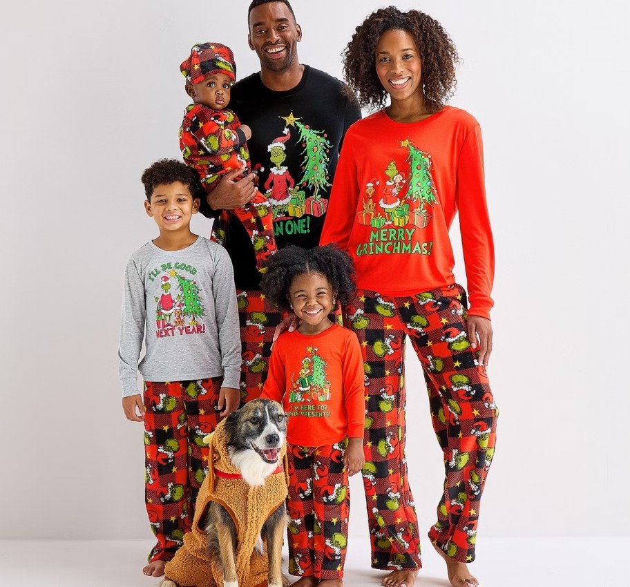 family of 4 wearing matching grinch plaid family pjs