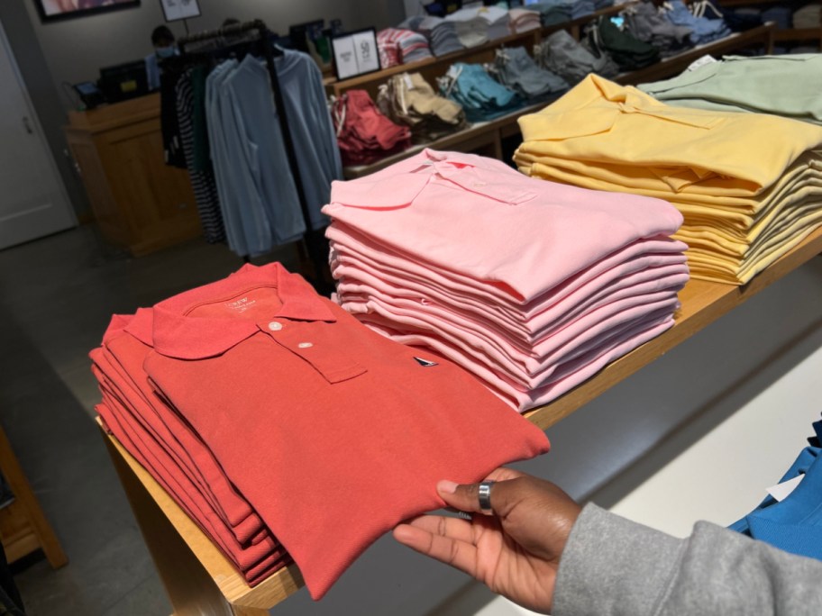 hand holding J. Crew Factory Men's Sweaters & Sweater Polos at the store