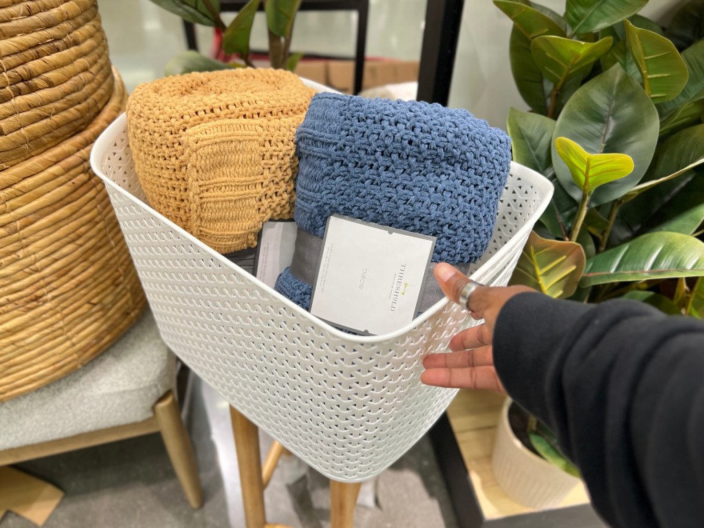 hand holding white large basket with towels at the target