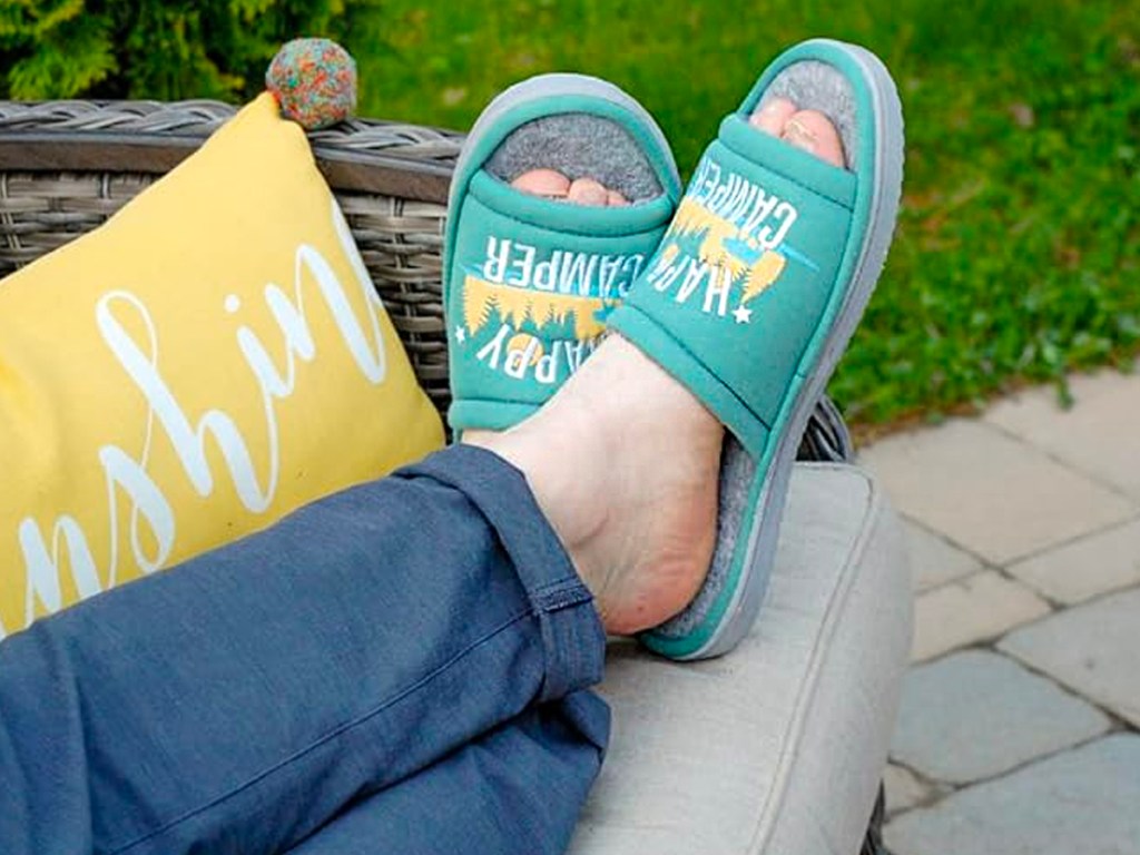 happy camper slippers on feet laying on couch