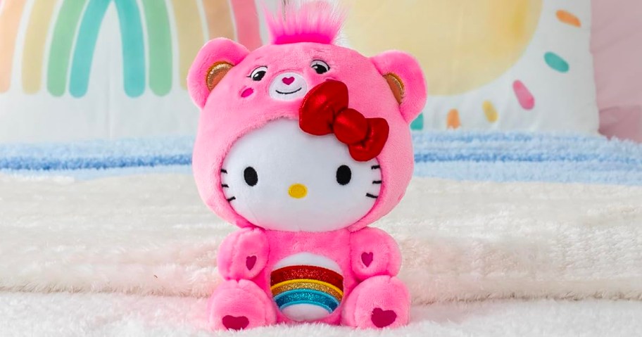 hello kitty dressed as care bear on bed