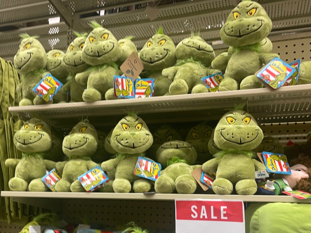 hobby lobby display if grinch plush with a sale sign in front