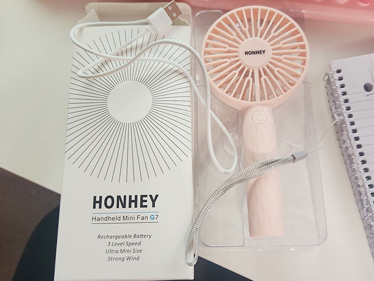 pink handheld fan next to box with wire