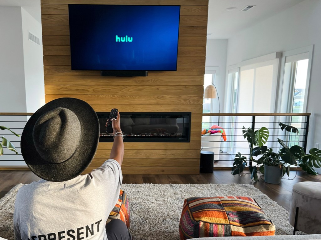 woman using remote to watch hulu on tv