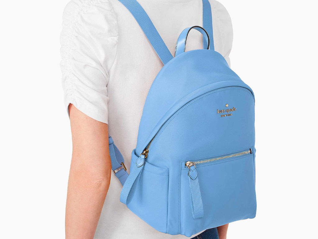woman wearing blue kate spade backpack