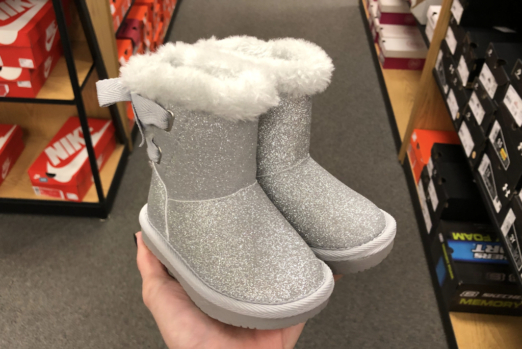 holding Kohl's kids boots 