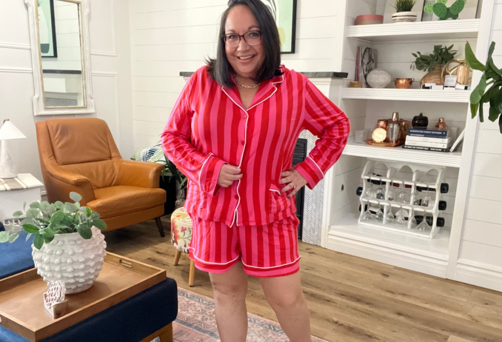 woman wearing pink stripped short pjs set standing in a living room