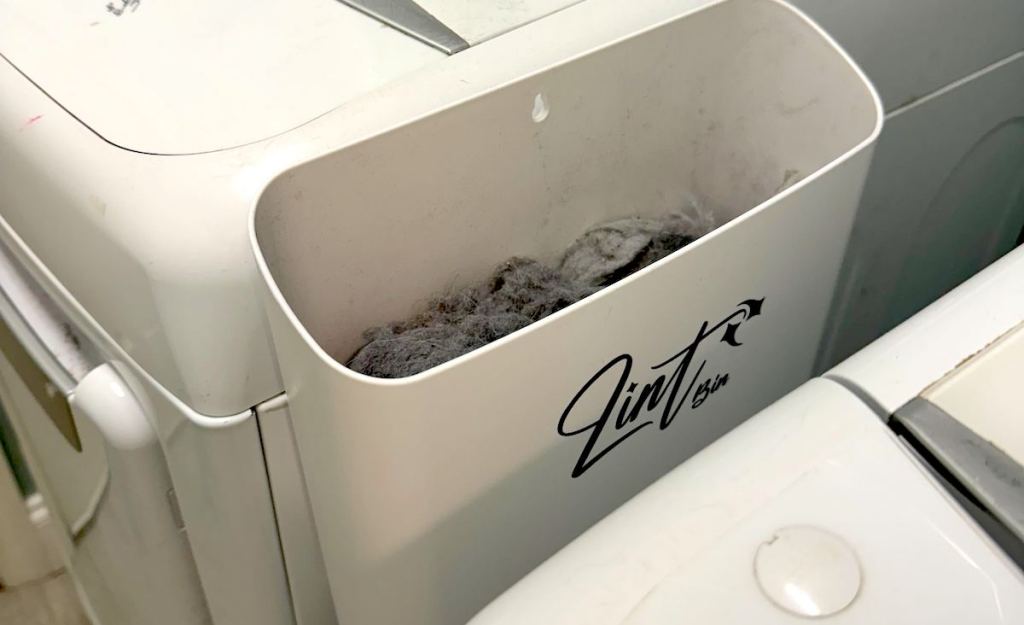 white lint bin sticking to side of washing machine