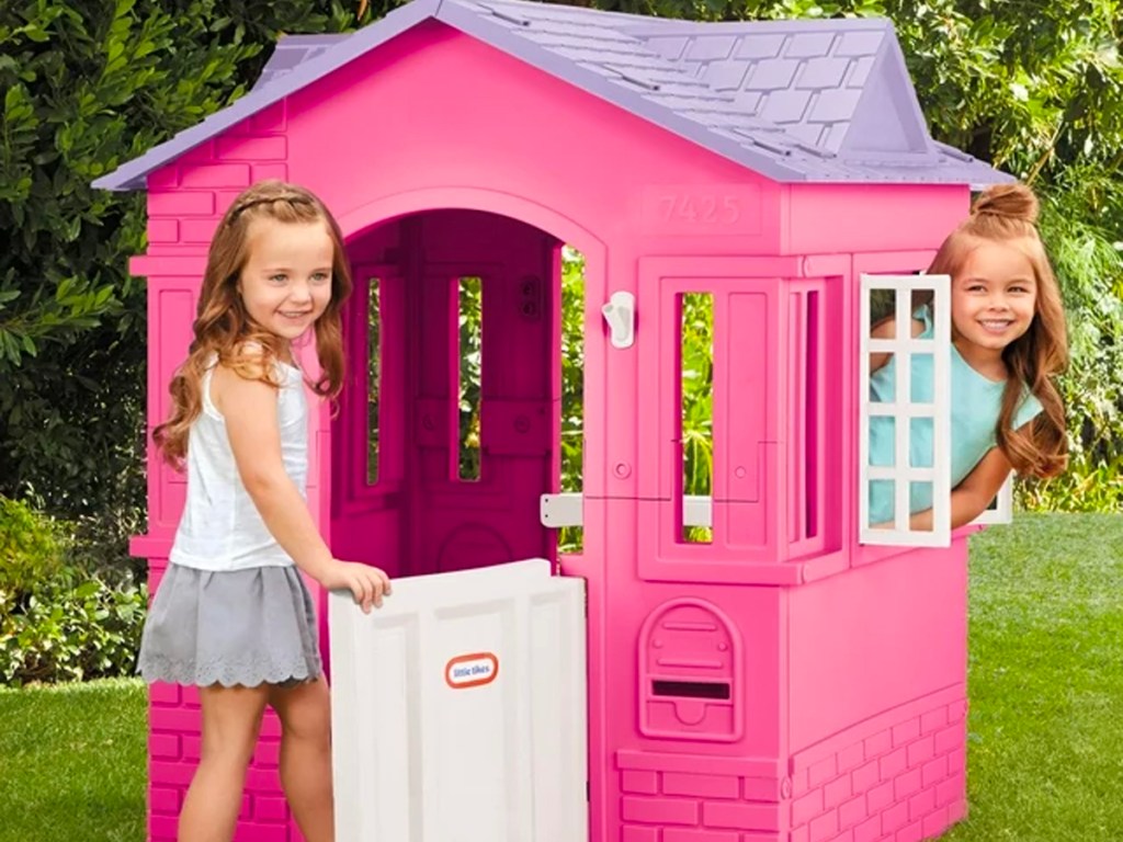 two girls playing in pink and purple little tikes playhouse
