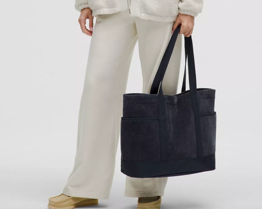 woman holding black tote bag