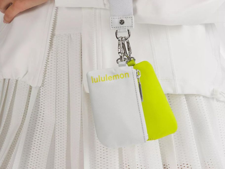 A person carrying a lululemon Dual Pouch Wristlet in Vapor and Lichen Lime