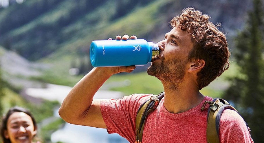 man drinking from a wide mouth hydro flask water bottle in blue