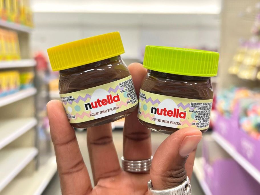 two mini jars of nutella being held up