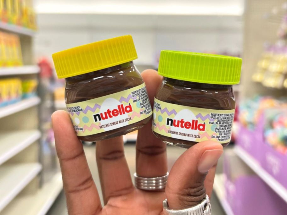 two mini jars of nutella being held up