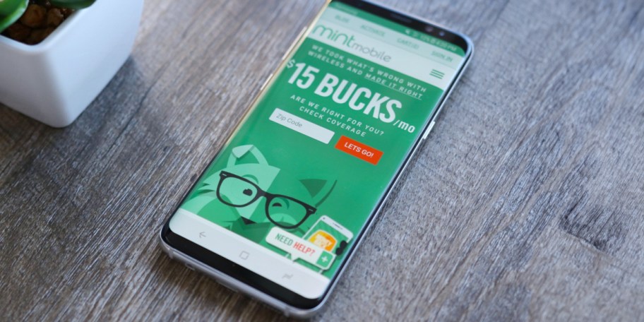 phone laying on table with mint mobile ad