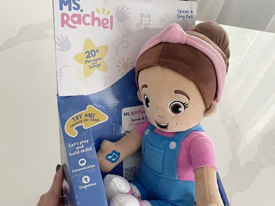 hand holding ms rachel doll over bed