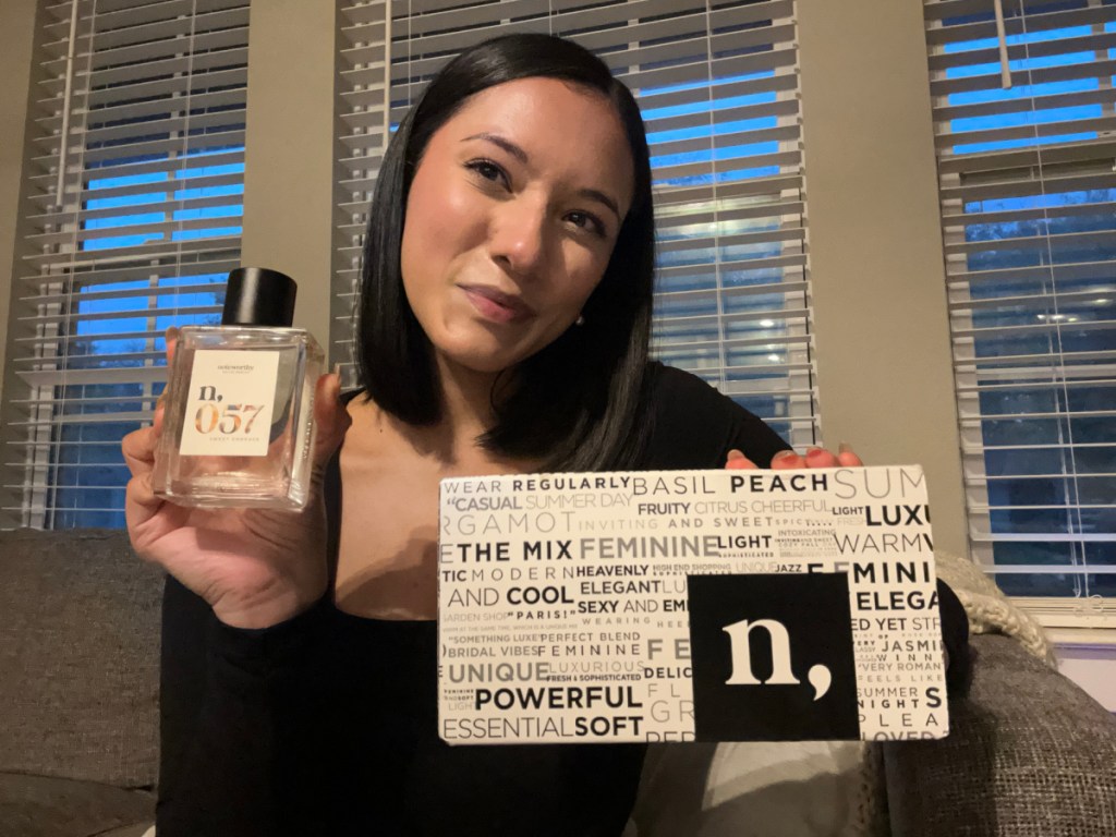 woman holding perfume and box