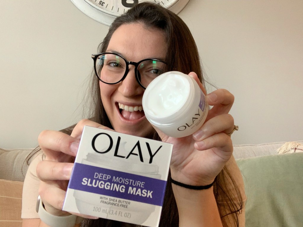 woman holding up a jar of olay slugging mask
