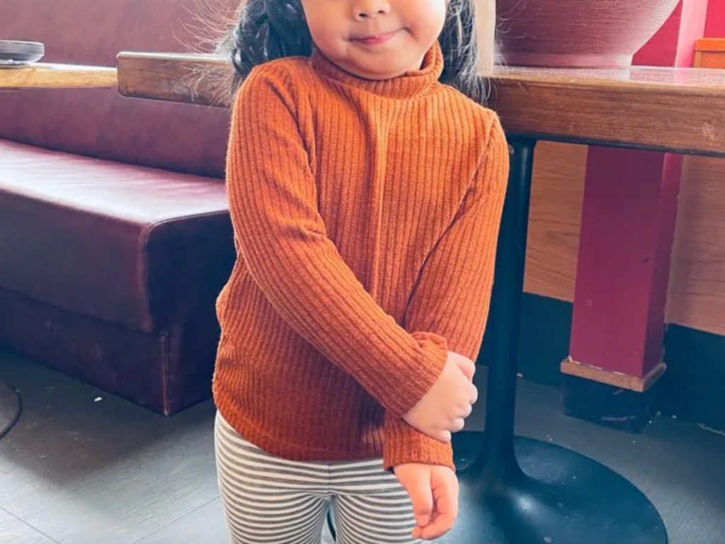 girl wearing orange turtleneck