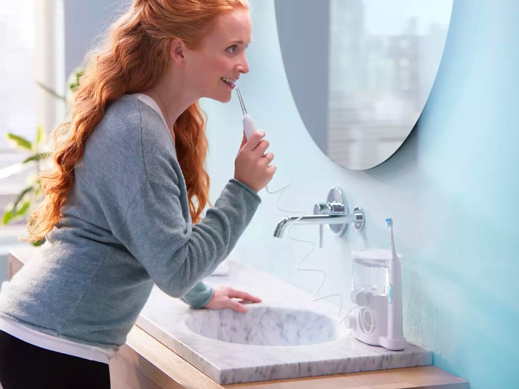 woman using phillips flosser in bathroom