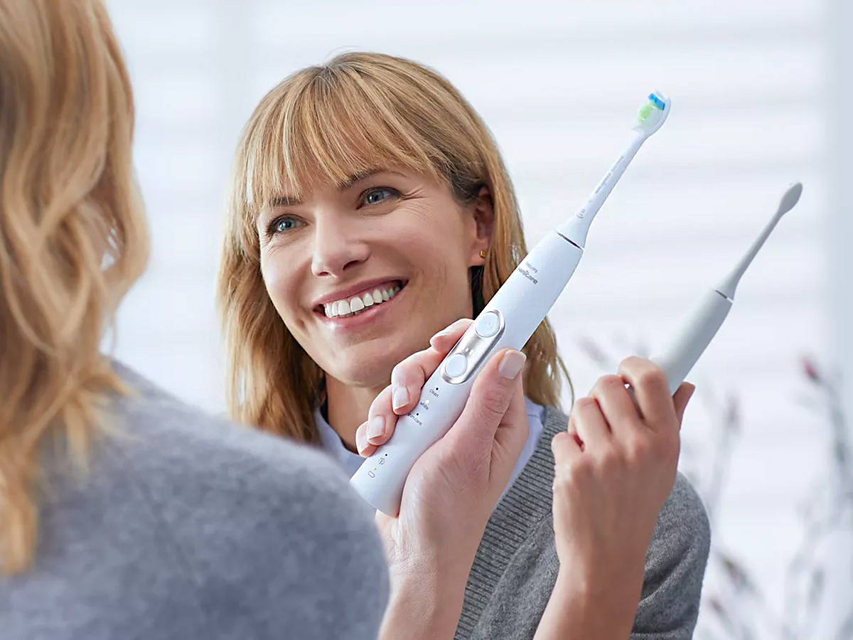woman holding white toothbrush