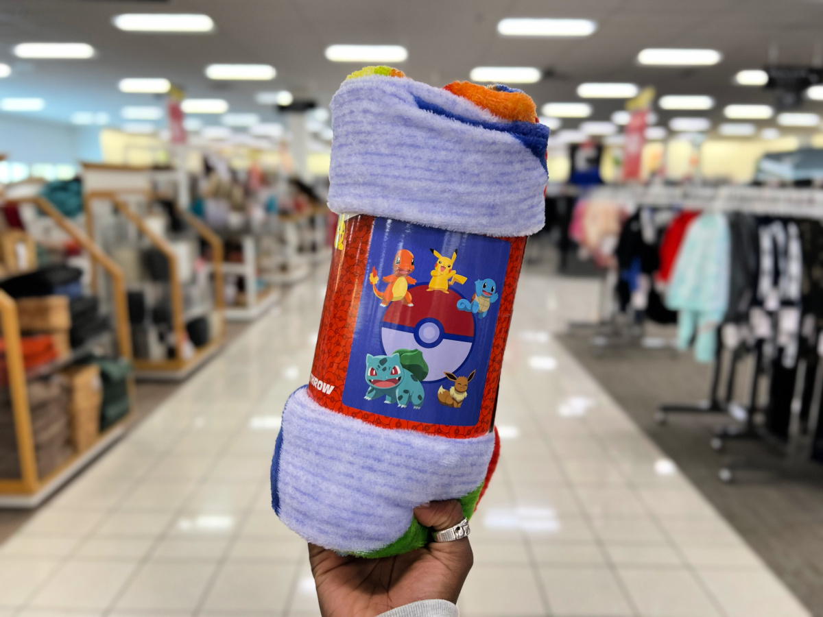 hand holding a pokmeon blanket in a kohls store