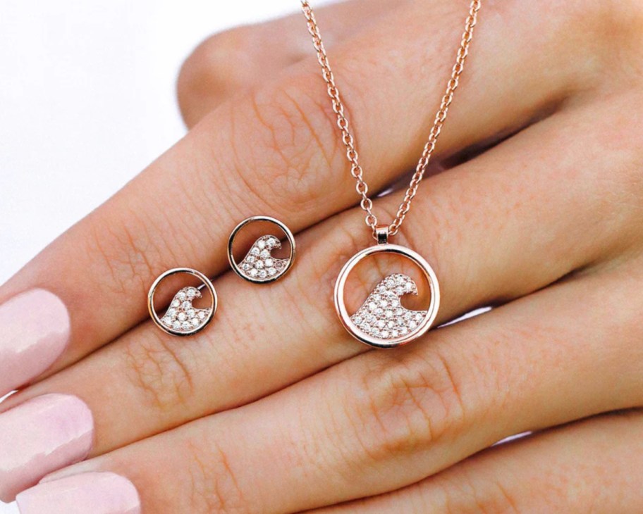 hand holding wave necklace and earrings