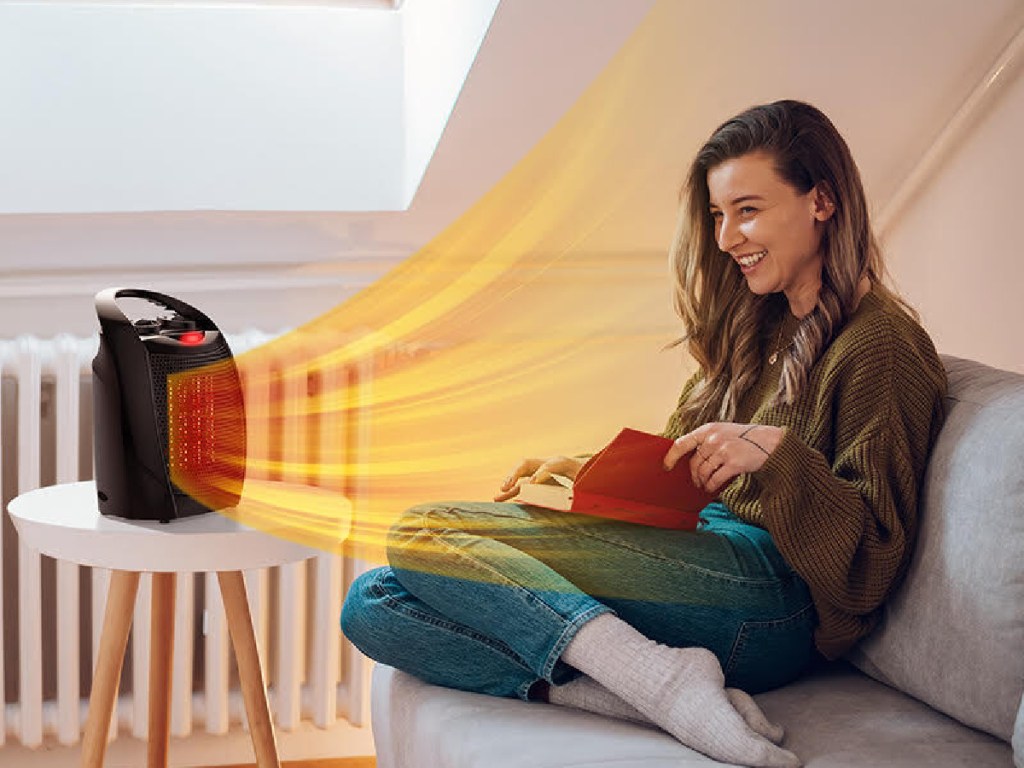 woman sitting on the couch in front of a rintuf heater