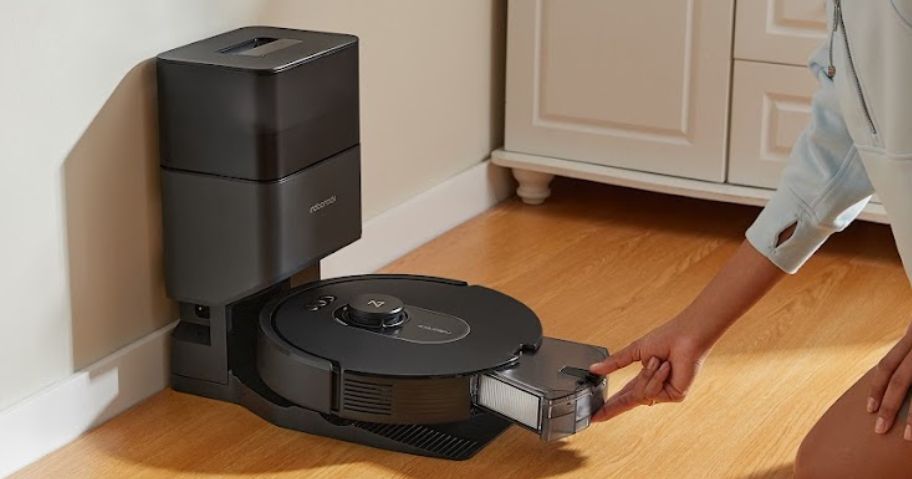 women taking out tray on a roborock vacuum