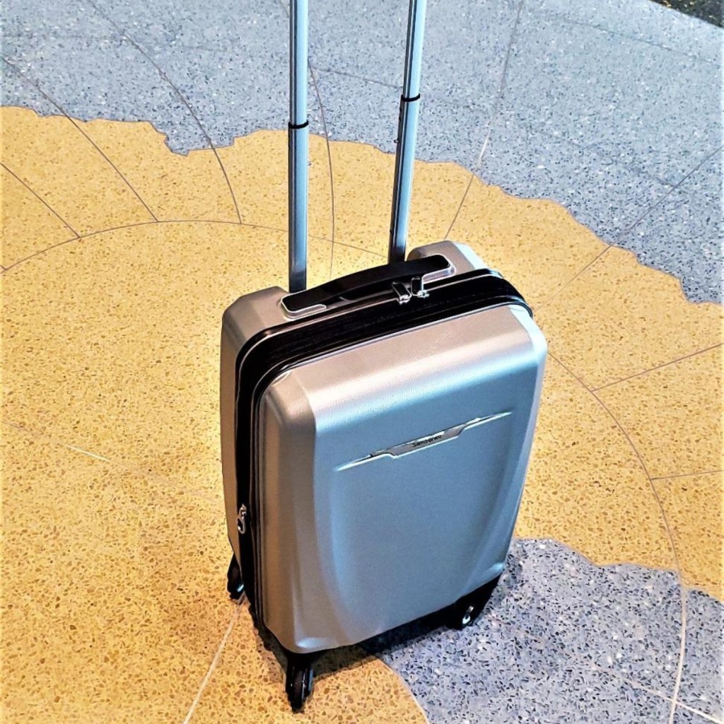 silver luggage on airport floor
