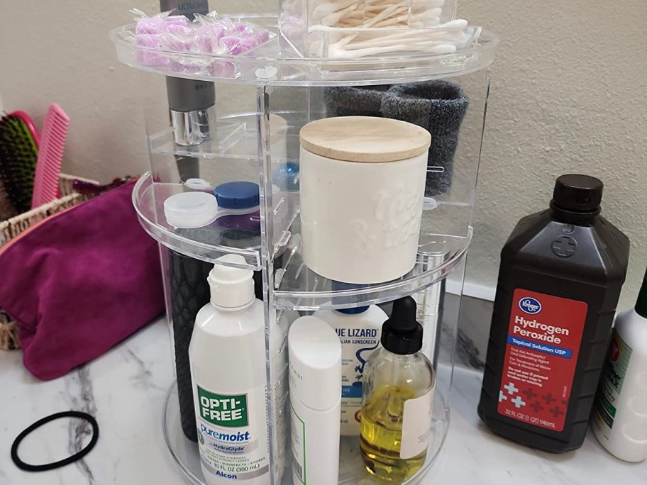 clear makeup organizer full of beauty products on bathroom counter