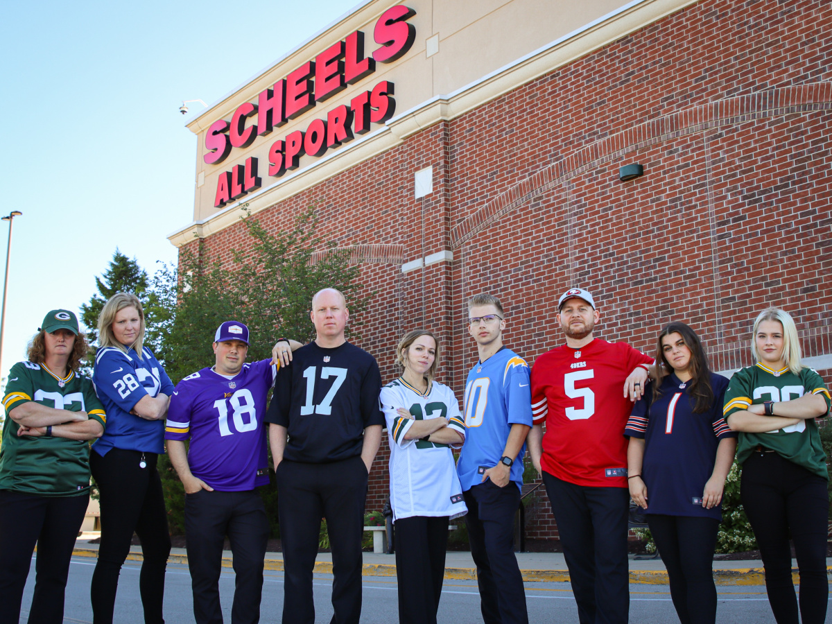 line of people wearing NFL jerseys in front of a scheels sports store