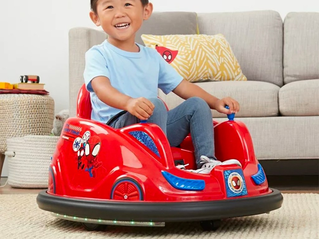 kid driving a spiderman bumper car toy
