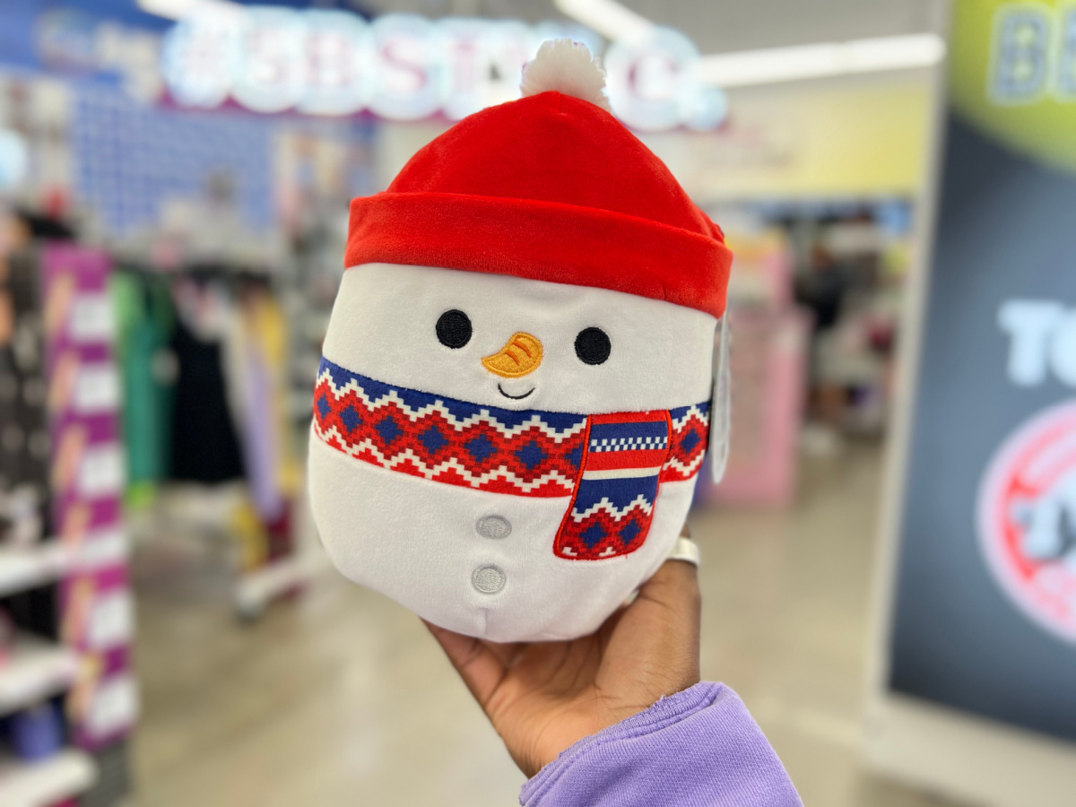 hand holding up a snowman squishmallows in a five below store