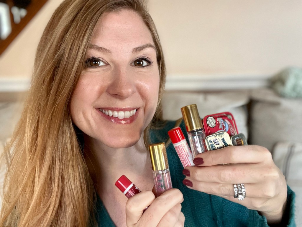 Woman holding various types of tinte cosmetic lip products 