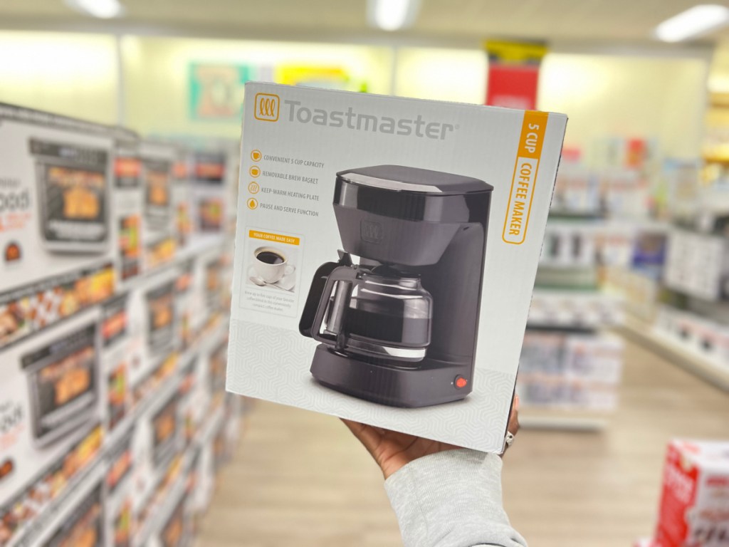 hand holding a toastmaster coffee maker box in the middle of a kohls aisle