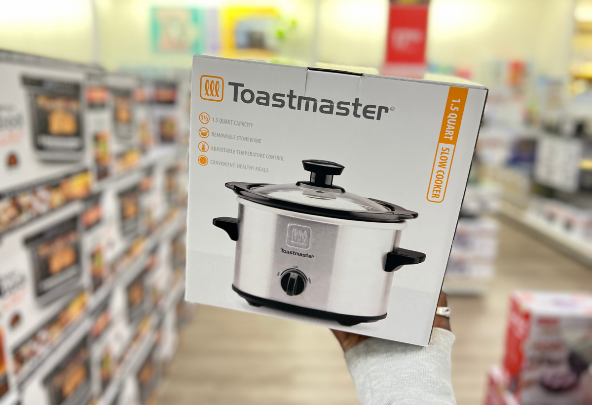 hand holding a toastmaster slow cooker box in the middle of a kohls store aisle